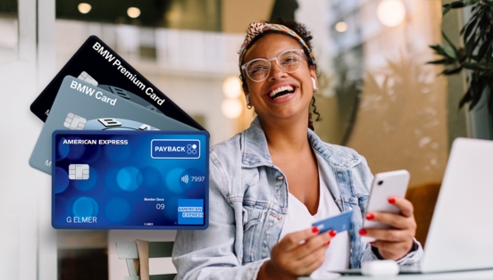 Fächer mit verschiedenen Kreditkarten von American Express, im Hintergrund eine moderne, lachende Frau mit Smartpone und blauer Kreditkarte in einem Café.