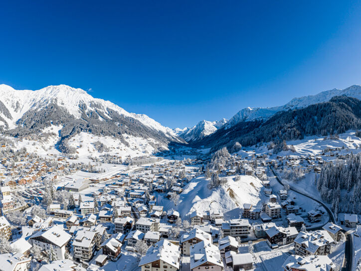 Blick auf die verschneite und im Tal liegende Ortschaft Klosters