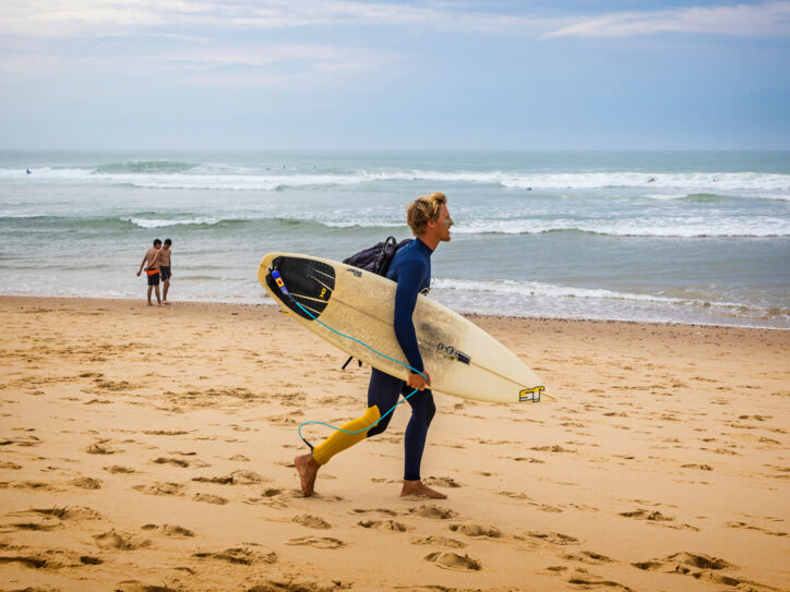 Ein Surfer mit Surfbrett an einem Strand