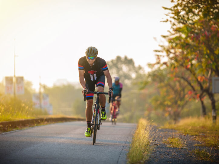 Zwei Rennradfahrer auf einer Straße im Abendlicht