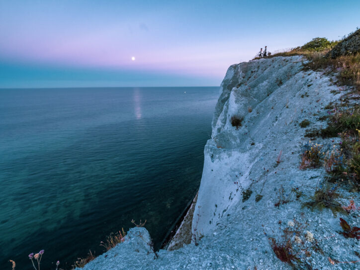 Zwei Radfahrende stehen an den Klippen von Møns Klint und schauen aufs Meer