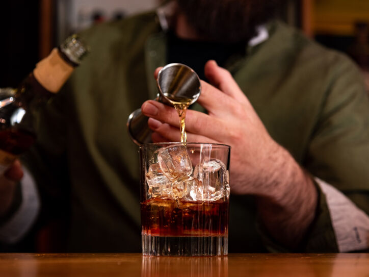 Ein Barkeeper gießt ein Glas Whisky ein.