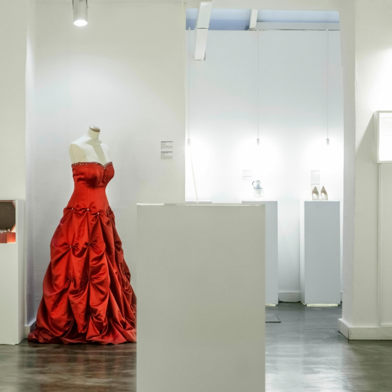 Ein rotes Abendkleid auf einer Schneiderpuppe in einem weißen Showroom