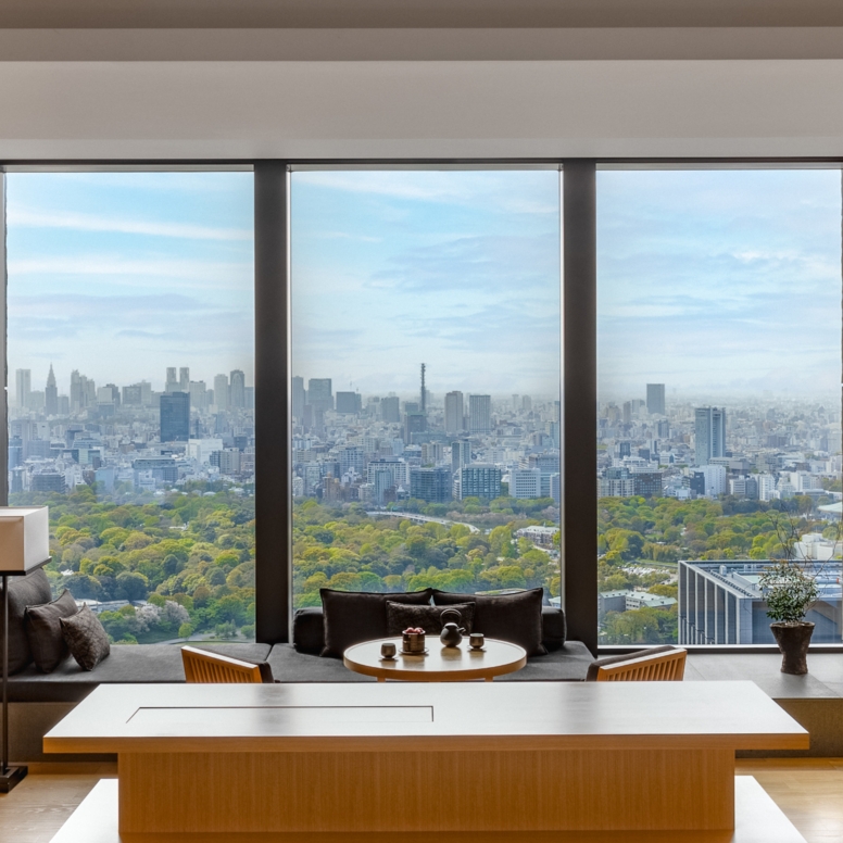 Hotelsuite im japanischen Stil mit Blick durch ein bodentiefes Panoramafenster auf die Skyline von Tokio