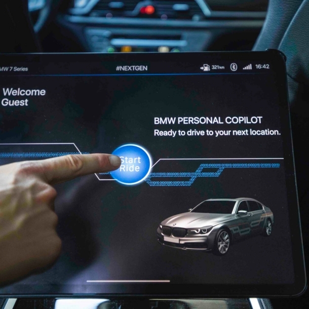 Auf einem Touchscreen im Auto wird die autonome Fahrfunktion durch Antippen mit dem Finger aktiviert