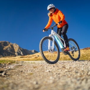 Eine Frau fährt auf einem Mountainbike einen Berg herunter