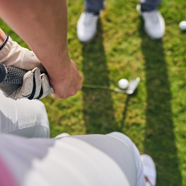 Blick von oben auf eine Person, die einen Golfschläger für den Abschwung hält