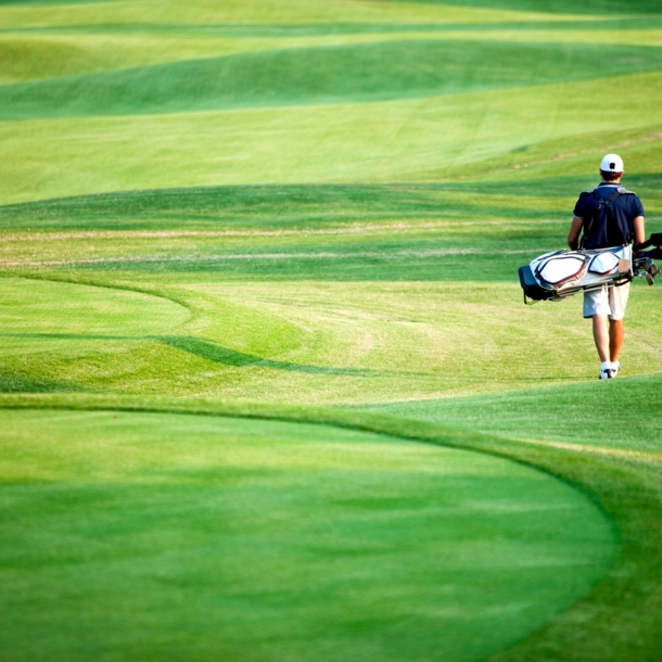 Golfspieler mit Equipment auf Golfplatz