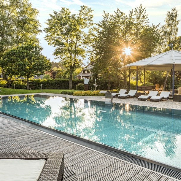 Elegante Terrasse mit Außenpool und Liegestühlen in begrünter Umgebung