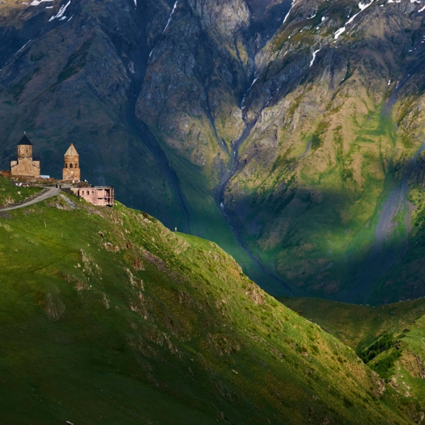 Grüne Berglandschaft in Georgien und Blick auf die Dreifaltigkeitskirche