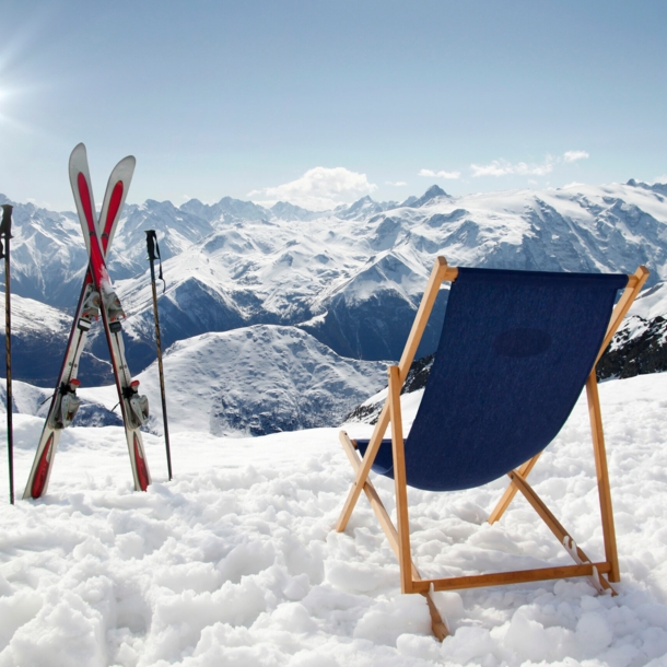 Ein Liegestuhl und Ski mit Stöcken auf einem Berg im Schnee