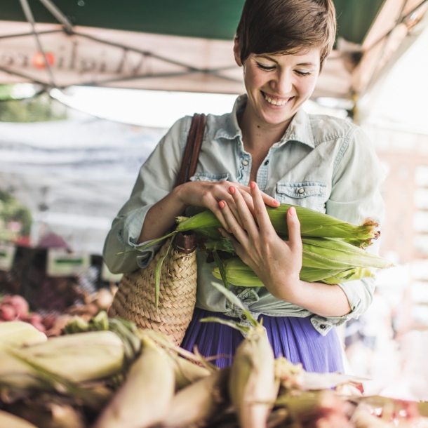 Eine Frau kauft frisches Gemüse auf dem Markt