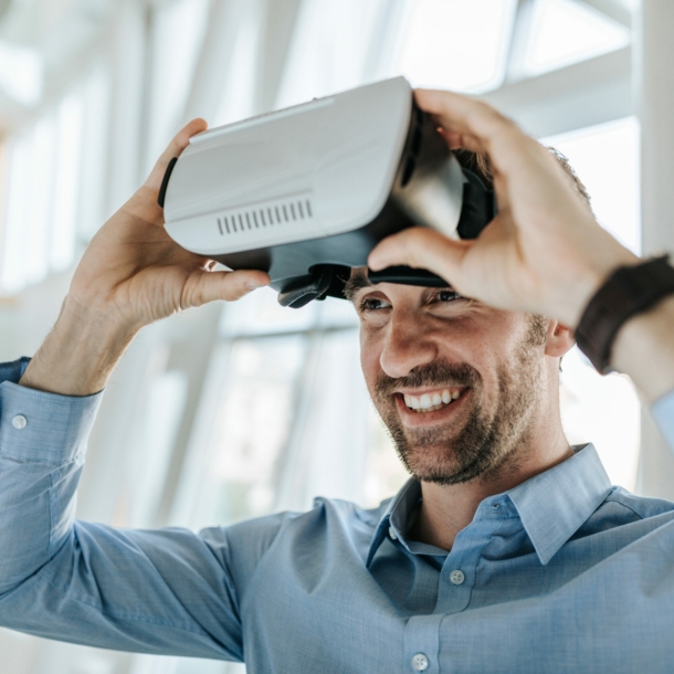 Ein junger Mann setzt eine VR-Brille ab.