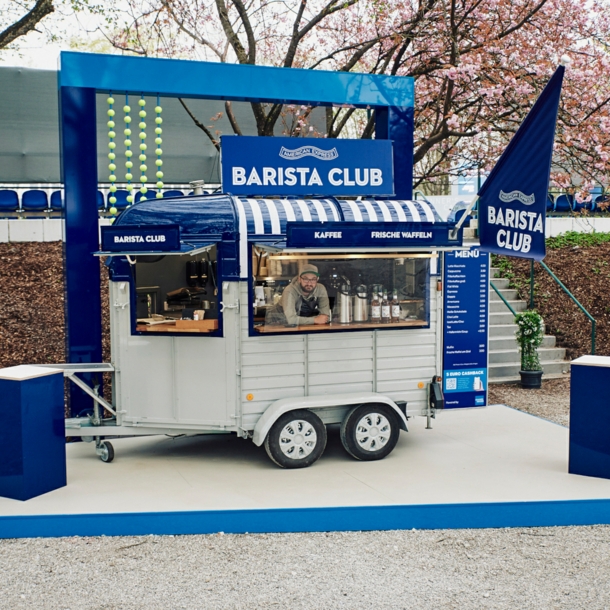 Pferdewagen, der zur mobilen Kaffeestation umgebaut wurde, in dem ein Mann bedient