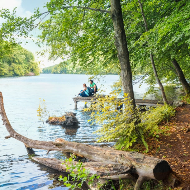 Wanderer pausieren auf einem Steg am Schmalen Luzin im Naturpark Feldberger Seenlandschaft