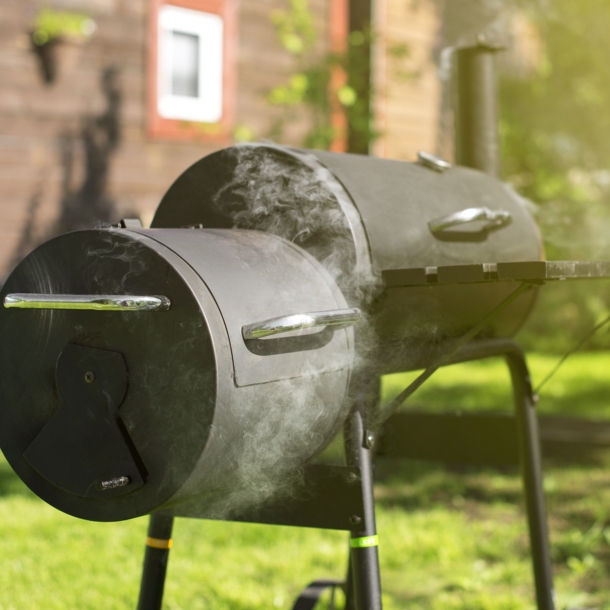 Ein qualmender Holzkohlegrill, in dem geräuchert wird