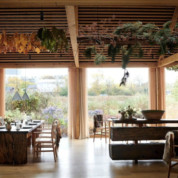 Innenraum eines Restaurants mit Blick nach draußen auf eine Wiese voller Wildblumen