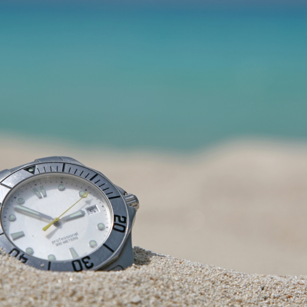 Taucheruhr mit Stahlgehäuse und weißem Zifferblatt in hellem Sand