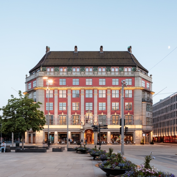 Prächtiges, beleuchtetes rotes Gebäude, davor ein großer Platz