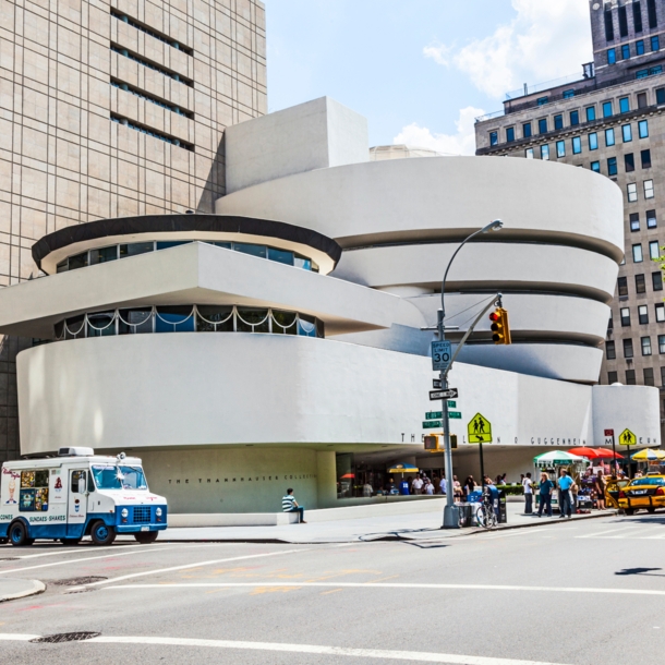 Blick auf das Guggenheim-Museum in New York, davor Autos und Menschen