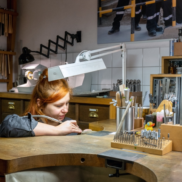 Eine Goldschmiedin im Atelier Jan Spille bei der Arbeit