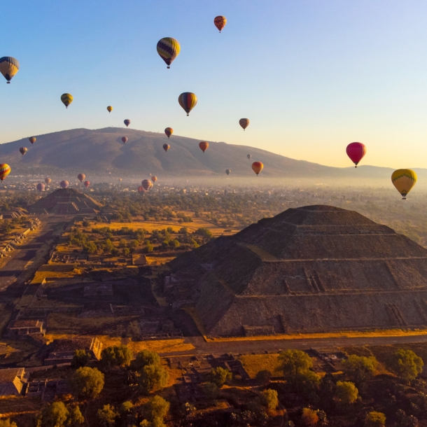 Heißluftballons über Pyramiden auf einer archäologischen Ruinenstätte bei Sonnenaufgang