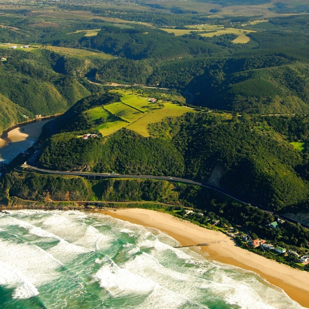 Luftaufnahme der Garden Route, die durch grüne Wälder entlang der Küste führt