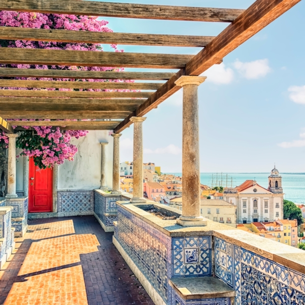 Terrasse mit portugiesischen Kacheln und Bougainvillea mit Blick auf Lissabon am Meer