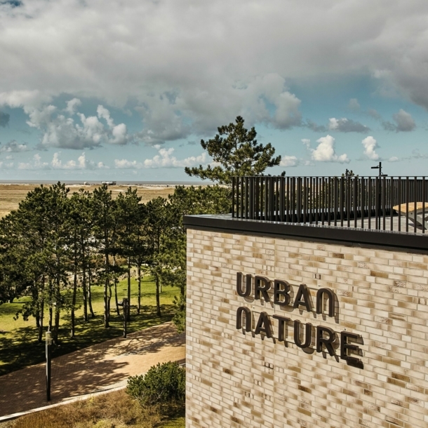 Blick auf die Dachterrasse des Urban Nature Hotels St. Peter Ording, im Hintergrund Bäume, Dünen, Meer und Wolken