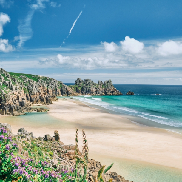 Blick auf die Küste von Cornwall mit Sandstrand, kristallblauem Wasser und Felsvorsprüngen