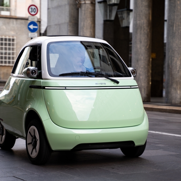 Mintfarbenes Elektrokleinfahrzeug auf einer Straße