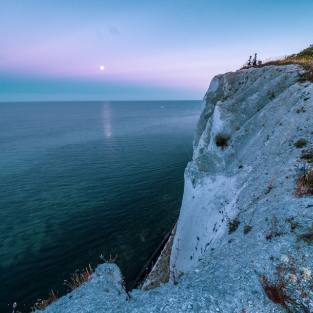 Zwei Radfahrende stehen an den Klippen von Møns Klint und schauen aufs Meer