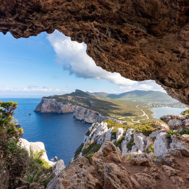 Blick zwischen Felsen hindurch auf eine Landzunge Sardiniens