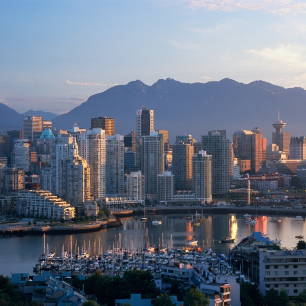 Skyline von Vancouver vor Bergpanorama in der Abenddämmerung.