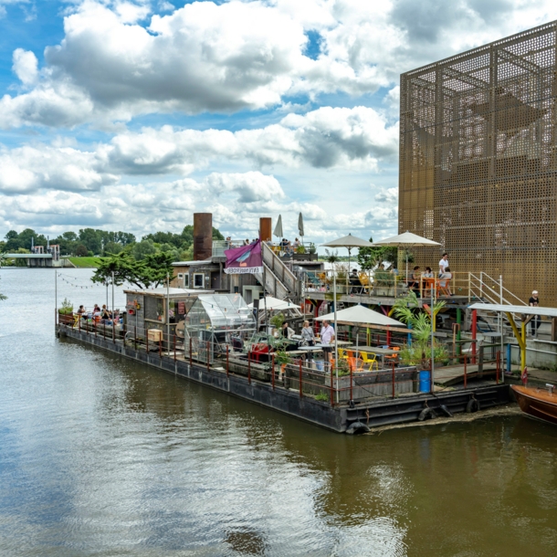 Ein Außencafé neben einem goldenen Pavillon auf einem Ponton.