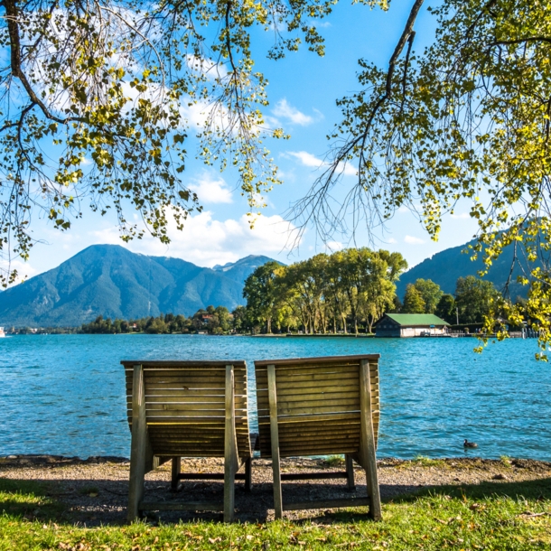 Zwei Holzliegen am Ufer des Tegernsees.