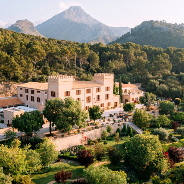 Das historische Hotel Castell Son Claret mit seiner grünen Parkanlage vor der Kulisse des Tramuntana-Gebirges.