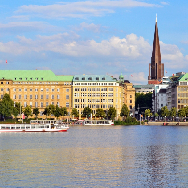 Häuserfront und Promenade am Wasser mit Booten in der Hamburger Altstadt.