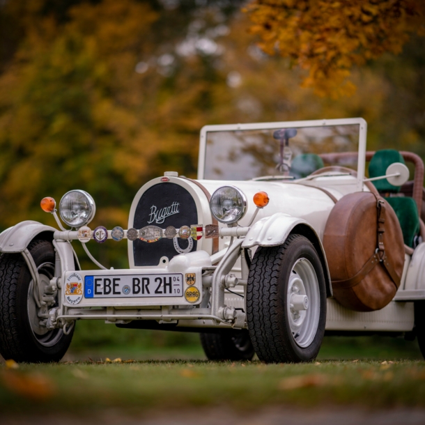 Weißer Bugatti Cabriolet Oldtimer mit H-Kennzeichen in einem Park.