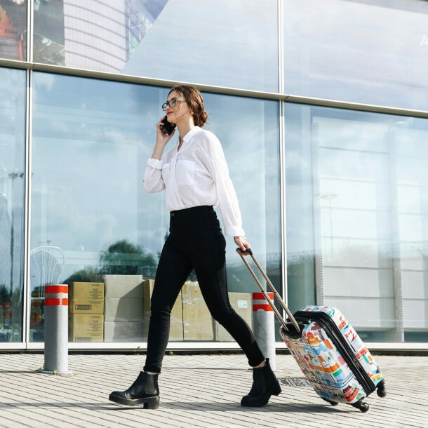 Geschäftsfrau mit Trolli auf dem Weg zum Flughafen