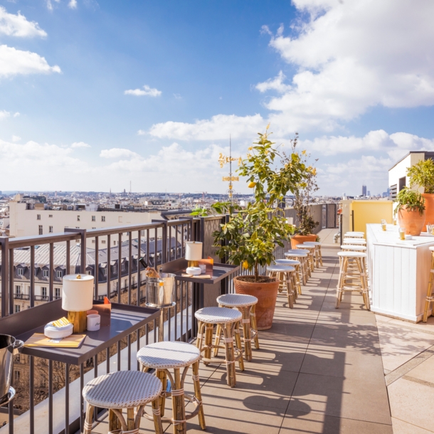 Dachterrasse des Restaurants Perruche mit Blick auf die Dächer von Paris und den Eiffelturm in der Ferne.