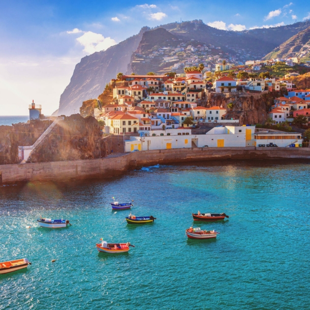 Panorama von Funchal auf Madeira mit Booten im Vordergrund und Bergen im Hintergrund.