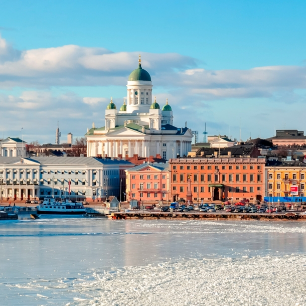 Stadtpanorama von Helsinki mit Dom an einer zugefrorenen Wasserfläche im Vordergrund.