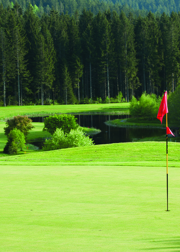 Eine rote Fahne auf dem hügeligen Golfplatz