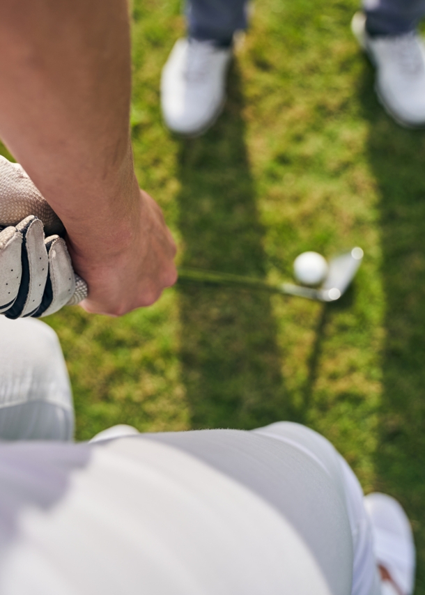 Blick von oben auf eine Person, die einen Golfschläger für den Abschwung hält