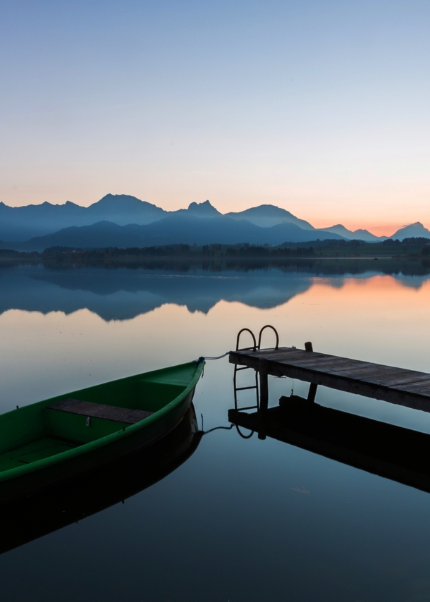 Der See Hopfen in den Bayerischen Alpen mit Boot und Steg bei Dämmerung