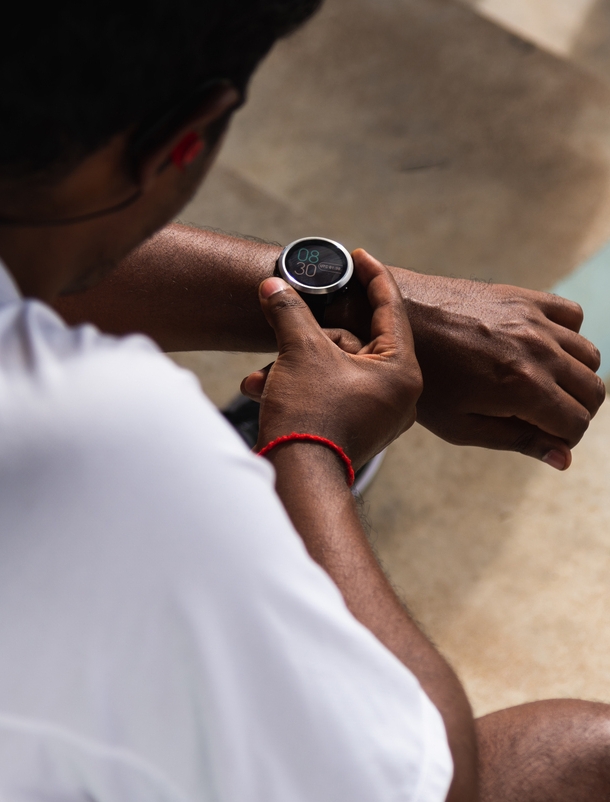 Ein Mann in Sportkleidung mit Armbanduhr mit Digitalanzeige am Handgelenk