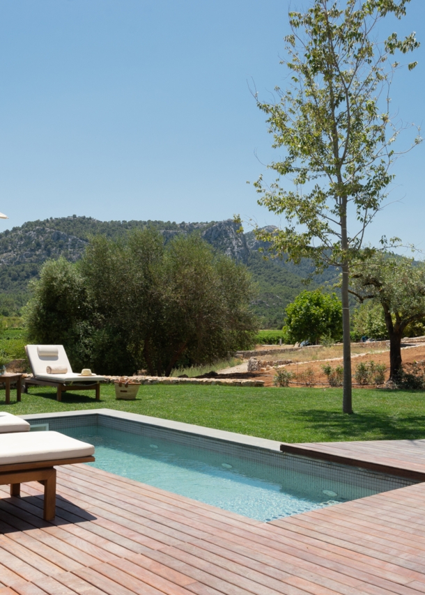 Ein kleiner Pool und Sonnenliegen vor einer bergigen Landschaft