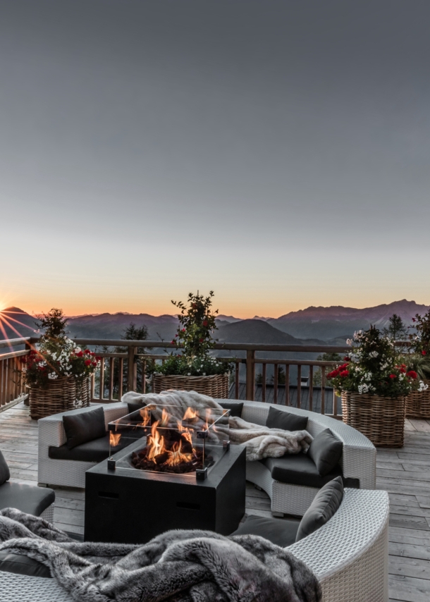 Eine Terrasse mit Feuerstelle und Blick über die Alpen