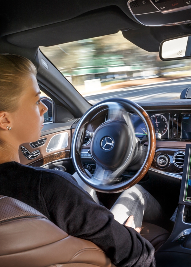 Blick in das Cockpit eines Pkw. Die Hände der Fahrerin sind nicht am Lenkrad